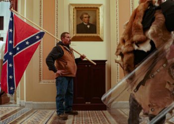 Standing atop the Confederate flag
